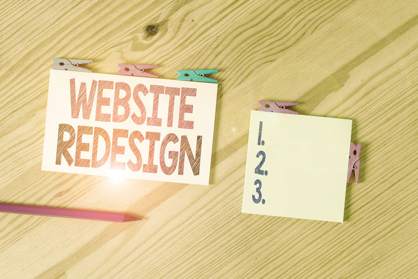 Writing note showing Website Redesign. Business photo showcasing modernize improver or evamp your website look and feel Colored clothespin papers empty reminder wooden floor background office. Redesign with Search in Mind